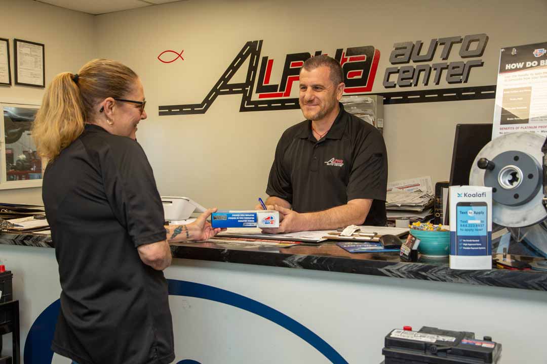 Staff at Alpha Auto Center talking at the front desk